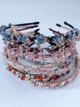 Stack of decorative headbands with crystals on a light background